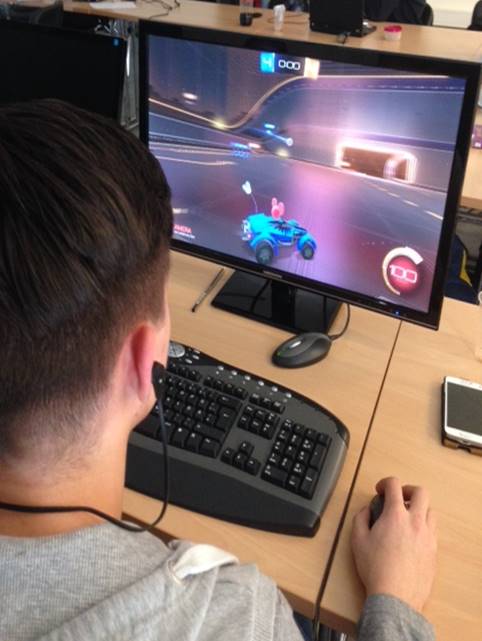 Jemand sitzt an einem Computer und spielt ein Rennspiel. 