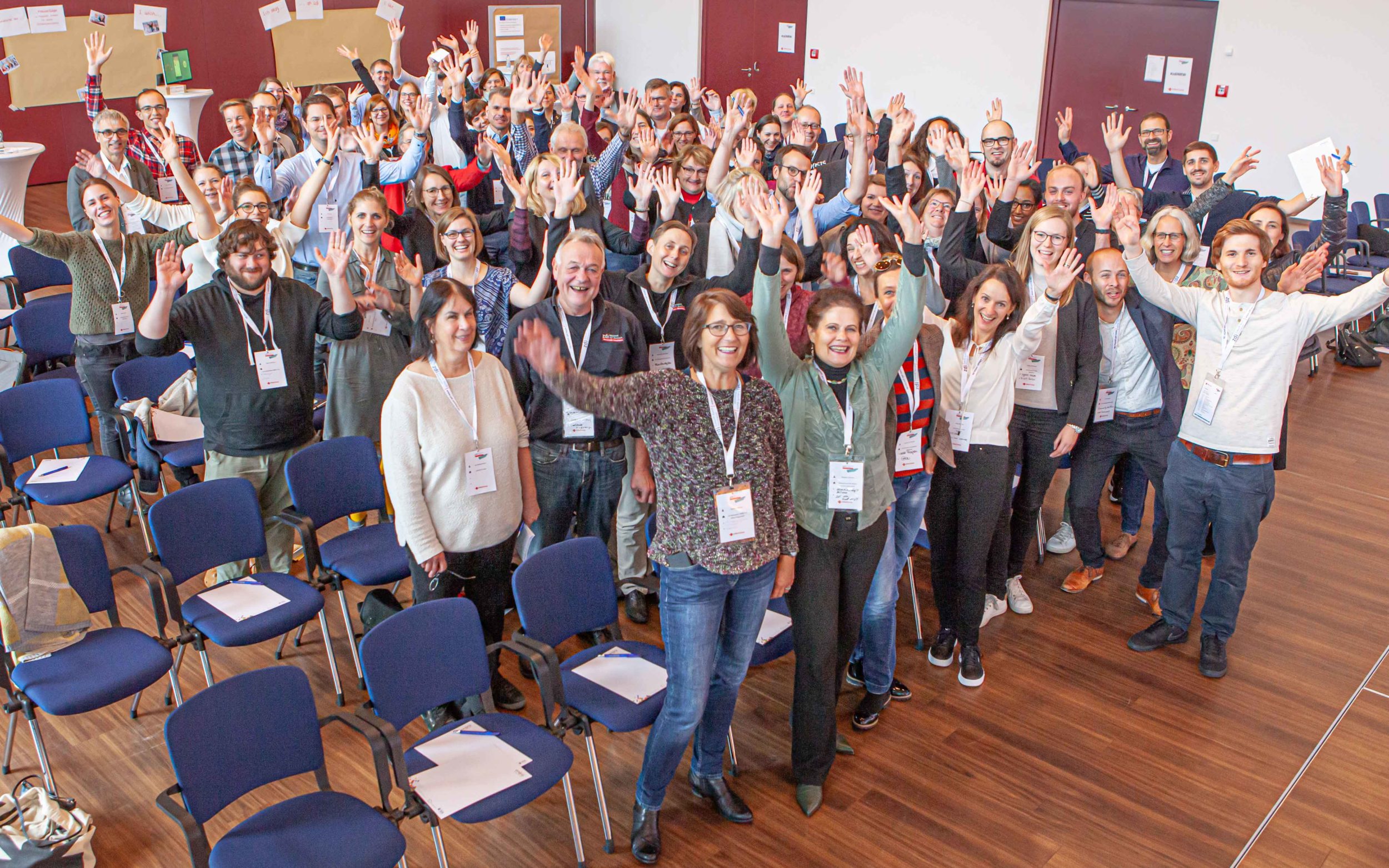 Viele Menschen jubeln in die Kamera. 