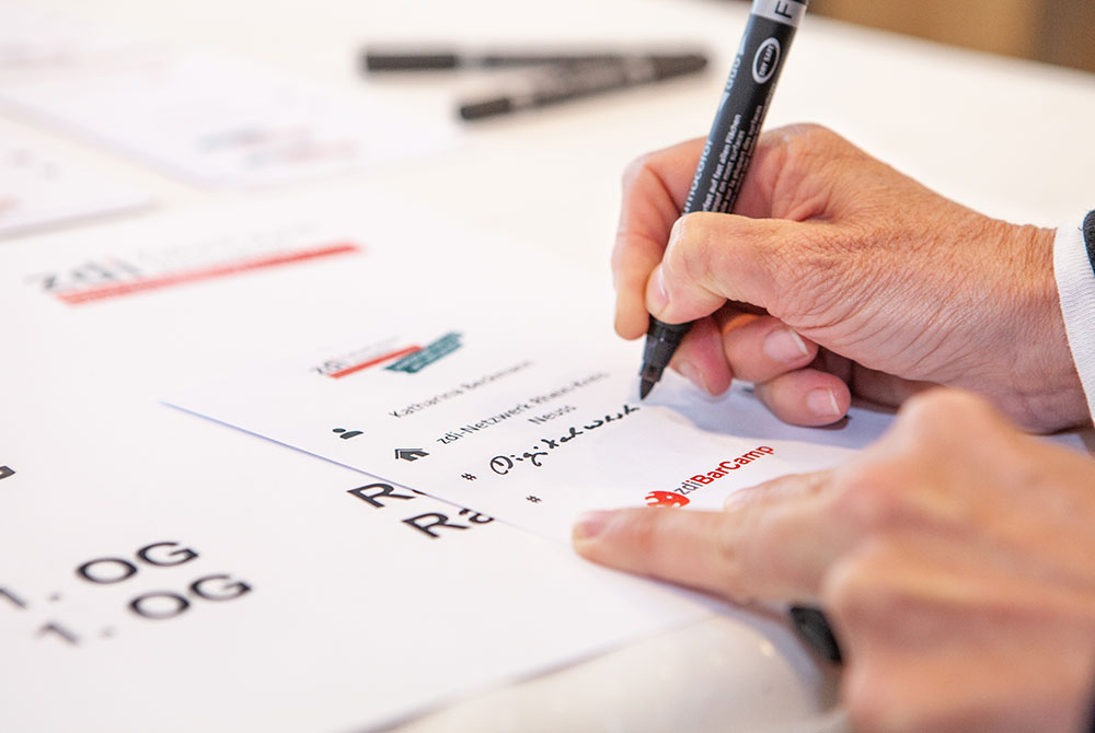 Jemand schreibt etwas auf einen Zettel. 