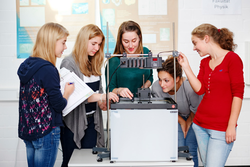 Bir makinenin etrafında duran bir grup genç kadın. ©2014 zdi.NRW