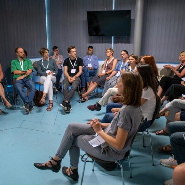 A group of people sit on chairs in a room.