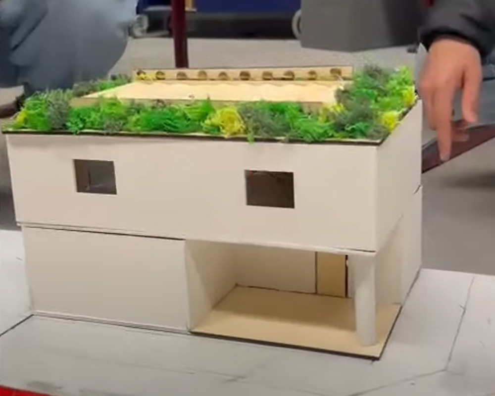 Yeşil çatılı bir evin modeli.