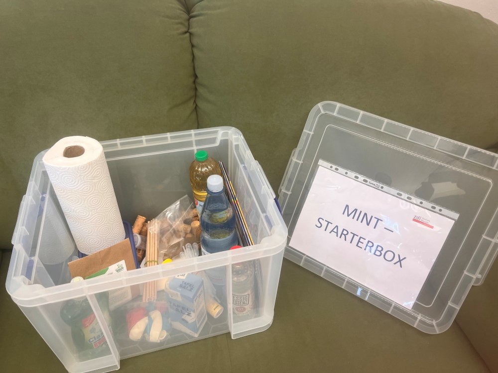 Das Foto zeit eine MINT-Starterbox mit unterschiedlichen Utensilien für alltagsnahe Experimente.